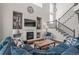 Inviting living room with a fireplace, built-in shelves, high ceilings, and a staircase to the upper level at 9570 Kendrick Way, Arvada, CO 80007