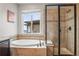 Luxurious main bathroom featuring soaking tub, tiled shower, and natural light at 9570 Kendrick Way, Arvada, CO 80007