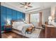 Stylish main bedroom with a striking blue accent wall, hardwood floors, and tray ceiling at 9570 Kendrick Way, Arvada, CO 80007