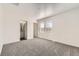 Neutral carpeted bedroom featuring a sunny window and ensuite bathroom at 400 Smith Cir, Erie, CO 80516