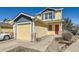 Charming yellow two-story home with a driveway and a bright red front door at 400 Smith Cir, Erie, CO 80516