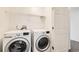 Well-lit laundry area with white washer and dryer set, plus convenient storage shelves at 400 Smith Cir, Erie, CO 80516