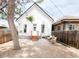 Quaint backyard patio with gravel, seating and a well-maintained, white-painted brick house with new wooden stairs at 230 E Ellsworth Ave, Denver, CO 80209