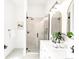 Bright bathroom featuring double vanity, black hardware, a glass shower door, and modern fixtures at 230 E Ellsworth Ave, Denver, CO 80209