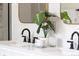 Bathroom features a white double vanity with black fixtures, quartz countertop, and gold-framed mirrors at 230 E Ellsworth Ave, Denver, CO 80209