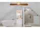 Bright bathroom boasts soaking tub and glass shower with modern fixtures; view to bedroom and stairway at 230 E Ellsworth Ave, Denver, CO 80209