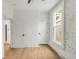 Light filled bedroom features hardwood floors, large window, and painted brick accent wall at 230 E Ellsworth Ave, Denver, CO 80209