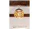 Modern gold light fixture with webbed pattern hung from wood beams at 230 E Ellsworth Ave, Denver, CO 80209