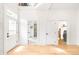 Hallway featuring hardwood floors, white trim, and a view into the bathroom and laundry room at 230 E Ellsworth Ave, Denver, CO 80209