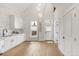 Modern kitchen features white cabinets, hardwood floors, and exposed brick accents and updated appliances at 230 E Ellsworth Ave, Denver, CO 80209