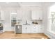 Bright white kitchen features stainless steel appliances, wood floors, and a white brick accent wall at 230 E Ellsworth Ave, Denver, CO 80209