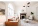 Bright and airy living room featuring a decorative fireplace, large arched window, and hardwood floors at 230 E Ellsworth Ave, Denver, CO 80209
