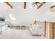 Lofted living area with a skylight, wood beams, neutral decor, and stylish light fixture at 230 E Ellsworth Ave, Denver, CO 80209
