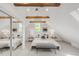 Stylish main bedroom offers vaulted ceilings, wooden beams, plush bedding, and mirrored closet doors at 230 E Ellsworth Ave, Denver, CO 80209