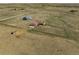 Aerial view of a property featuring a home, outbuilding, fenced yard, and vast surrounding land at 13640 County Road 182, Bennett, CO 80102