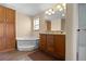 Spacious bathroom with a soaking tub, double vanity, and ample storage in wood cabinets at 13640 County Road 182, Bennett, CO 80102