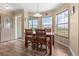 Sunlit dining area features a rustic wooden table and chairs, and expansive views of the surrounding landscape at 13640 County Road 182, Bennett, CO 80102
