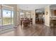 Open-concept dining room with wood flooring and a view of the connected kitchen area with a breakfast bar at 13640 County Road 182, Bennett, CO 80102