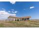 Home's exterior view shows attached garage, new landscaping, fenced yard and plentiful grass with bright blue sky at 13640 County Road 182, Bennett, CO 80102