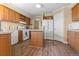 Functional kitchen with wood cabinets, white appliances, and a central island for meal preparation at 13640 County Road 182, Bennett, CO 80102
