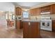 Well-lit kitchen area with wood cabinets and a breakfast bar overlooking the dining area, perfect for casual meals at 13640 County Road 182, Bennett, CO 80102