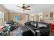 Comfortable living room features a ceiling fan, sleek black leather seating, and cozy, colorful accents at 13640 County Road 182, Bennett, CO 80102