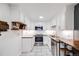 Well-lit kitchen featuring white cabinets, stainless steel appliances, subway tile backsplash, and butcher block countertops at 20 S Logan St # 104, Denver, CO 80209