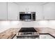 Close-up of kitchen appliances, including an oven, cooktop, and built-in microwave at 20 S Logan St # 104, Denver, CO 80209
