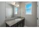 A well-lit bathroom vanity with a granite countertop, a single sink, and a large mirror at 630 E Hinsdale Ave, Littleton, CO 80122
