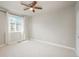 A bright bedroom with a ceiling fan and large window dressed with flowing white curtains at 630 E Hinsdale Ave, Littleton, CO 80122
