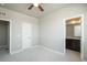 A bright bedroom with neutral tones with two doors, a ceiling fan, and a window at 630 E Hinsdale Ave, Littleton, CO 80122