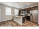 Well-lit kitchen boasts stainless steel appliances, dark cabinetry, a granite-topped island, and wood flooring at 630 E Hinsdale Ave, Littleton, CO 80122