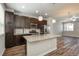 Gourmet kitchen with stainless steel appliances, dark cabinets, a granite island, and an open layout at 630 E Hinsdale Ave, Littleton, CO 80122