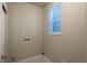 A clean laundry room featuring crisp white trim, a utility sink, and a window providing ample light at 630 E Hinsdale Ave, Littleton, CO 80122