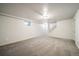 Unfurnished basement area with neutral carpet, lighting, stairs, and a small window at 6810 E Appleton Ct, Centennial, CO 80112