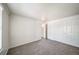 Bedroom with light gray carpet and white walls, view of hallway, and closet at 6810 E Appleton Ct, Centennial, CO 80112