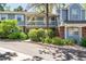 Charming townhome featuring a cozy balcony, lush landscaping, brick accents, and a welcoming facade at 6810 E Appleton Ct, Centennial, CO 80112