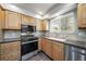 Bright kitchen featuring light wood cabinets, stainless steel appliances, and a window over the sink at 6810 E Appleton Ct, Centennial, CO 80112