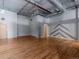 Large living room featuring exposed ductwork, hardwood floors, and painted wall art at 1301 Wazee St # 2D, Denver, CO 80204