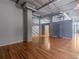 Spacious living room featuring concrete pillars, exposed ductwork, and hardwood floors at 1301 Wazee St # 2D, Denver, CO 80204