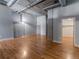 Bright living room with exposed concrete pillars, hardwood floors, and closet at 1301 Wazee St # 2D, Denver, CO 80204