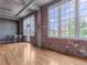 Bright living room with exposed brick wall, tall windows, and hardwood floors at 1301 Wazee St # 2D, Denver, CO 80204