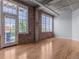 Living room with hardwood floors and a brick accent wall at 1301 Wazee St # 2D, Denver, CO 80204