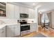 Kitchen with stainless steel stove and quartz counters open to dining area at 1073 Roslyn Ct, Denver, CO 80230