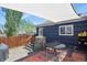 Relaxing backyard deck with a shade sail, a tree stump detail, string lights, and a gas grill at 3941 S Elati St, Englewood, CO 80110