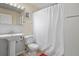 Modest bathroom featuring a toilet, shower with white shower curtain, and a classic pedestal sink at 3941 S Elati St, Englewood, CO 80110