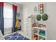 This bedroom features a colorful decor, a decorative blue rug, and ample storage with a white dresser at 3941 S Elati St, Englewood, CO 80110