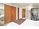 Simple bedroom with a large closet, a mirror, and a bed with white linens at 3941 S Elati St, Englewood, CO 80110