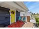 Cozy front porch featuring colorful rug, chairs and yellow front door at 3941 S Elati St, Englewood, CO 80110
