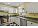 Cozy kitchen featuring white cabinets, checkerboard flooring, and a stainless steel dishwasher at 3941 S Elati St, Englewood, CO 80110